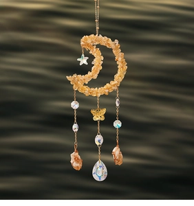 Macro detail of suncatcher featuring citrine crescent moon and hollow metal butterfly