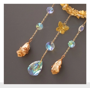 Detailed view of suncatcher featuring raw citrine stones and golden butterfly pendants