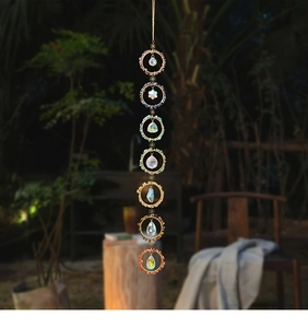Macro view of seven chakra crystals and multi-faceted prism pendants on gold dreamcatcher
