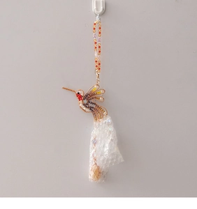 Detail of a handmade hummingbird suncatcher with colorful beads and wire-wrapped metalwork
