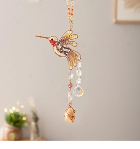 Detail of hummingbird suncatcher with natural crystals and colorful beads for garden decor