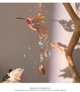 Detail of hummingbird dreamcatcher with colorful beads and crystal pendant reflecting light