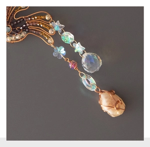Macro detail of copper wire wrapped crystal beads and natural gemstone on suncatcher