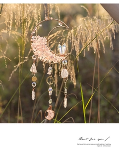 Detailed view of moon-shaped crystal suncatcher with pink stones and golden frame