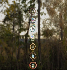 Detail of 7 chakra hanging crystals suncatcher with natural crushed stones and prisms