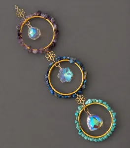 Detail van dromenvanger windgongen met gouden ringen, kleurrijke stenen en kristallen