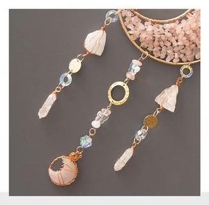 Detail of pink crystal moon suncatcher with raw quartz and golden wire wrapping