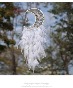 Detail of moon dreamcatcher with white feathers, green crystal tree, and pearl accents