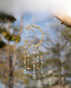 Detail of bohemian gold moon wind chime with natural yellow stones and crystal pendants