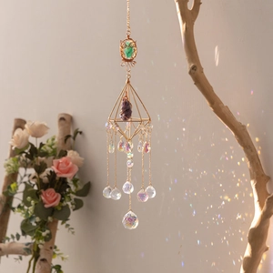 Golden suncatcher with purple amethyst and crystal prism hanging on a branch