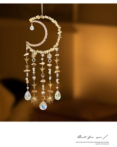 Detail of moon-shaped dream catcher with crushed stones and hanging crystal prism