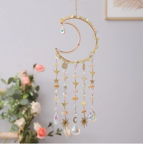 Macro view of moon-shaped dream catcher with crystals and golden hummingbird charms