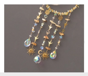 Close-up of golden wind chime with natural crystal stones and bohemian celestial charms