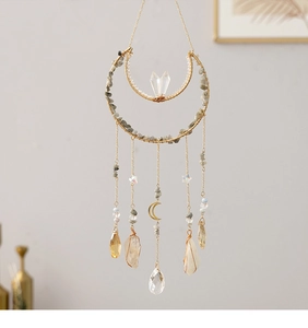 Detail of golden moon suncatcher with natural raw stones and hanging crystals