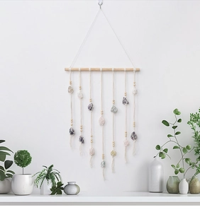 Detail of bohemian wall hanging featuring raw natural crystals and handmade cotton weave