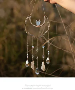 Detail of moon-shaped suncatcher with natural raw stones and faceted crystal pendants