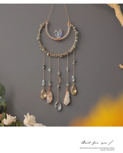 Detail of moon-shaped suncatcher with tree of life crystals and rose gold metal rings