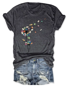 Close-up of dandelion book graphic on dark gray t-shirt with denim shorts outfit