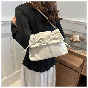 Detailansicht der beigen Falten-Cloud-Bag mit Schleifendeko und FASHION & BAGS Text