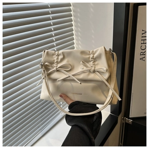 Detail der cremefarbenen PU-Leder-Einkaufstasche mit eleganten Schleifen und Falten