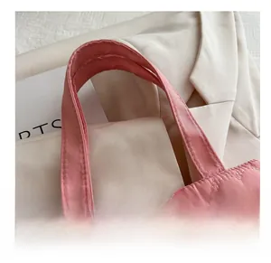 Close-up of pink quilted heart patterns and reinforced soft handles on the tote bag