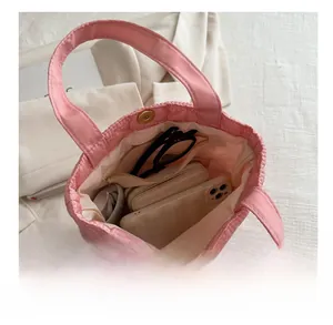 Internal storage view of pink quilted tote bag showing smartphone and wallet capacity