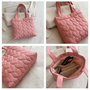 Detailed view of pink quilted heart tote bag showing inner storage and magnetic closure