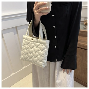 Detail of white heart-quilted nylon tote bag showing soft texture and sweet design