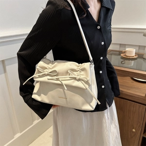 Cremefarbene Schultertasche mit Raffung und Schleifen in eleganter Innenansicht