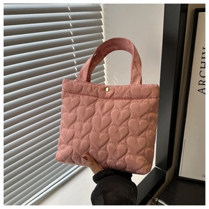 Close-up of pink quilted heart tote bag showing the golden metal magnetic closure detail