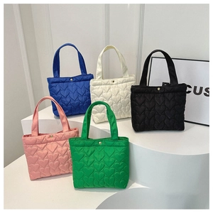 Detail of five-color heart-quilted tote bags with gold magnetic snap button closures