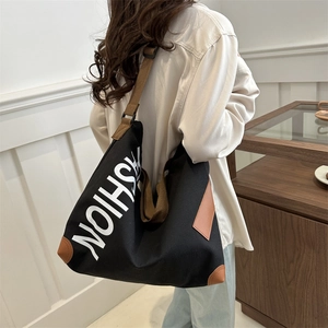 Large black canvas tote bag with FASHION print and adjustable brown shoulder strap