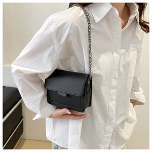 Black matte leather rectangular crossbody bag with gunmetal chain on female model