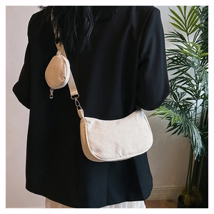 Gros plan sur le sac en velours côtelé blanc cassé avec une pochette ronde sur la bandoulière