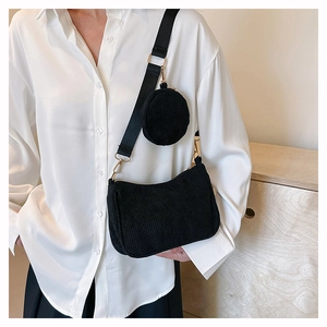 Détail du sac bandoulière en velours côtelé noir avec un petit porte-monnaie assorti