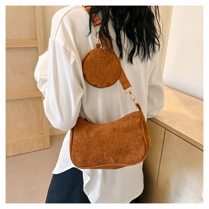Close-up of brown corduroy crescent bag and round coin purse set on shoulder strap