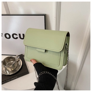 Detail of light green mini crossbody bag showing matte PU leather and silver chain strap