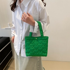 Vibrant green heart quilted tote bag with metallic snap button and stylish top handles