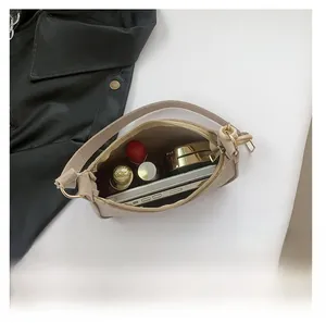 Top view of beige crocodile embossed baguette bag interior showing phone and cosmetics