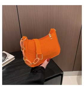 Detail of orange embossed crocodile pattern handbag with thick chain strap for women