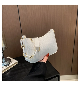 Detail of white crocodile pattern shoulder bag with resin and gold chain strap handle