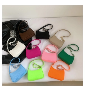 Flat lay of crocodile pattern baguette bags in ten colors with decorative chains