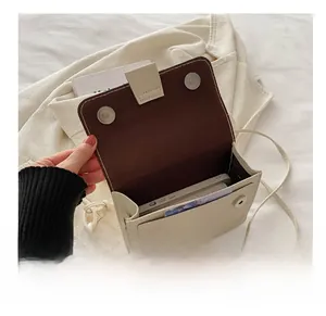 Dettaglio interno della borsa a tracolla crema con chiusura magnetica e porta cellulare