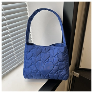 Détail du sac cabas bleu roi avec texture matelassée en cœur et poignée tressée