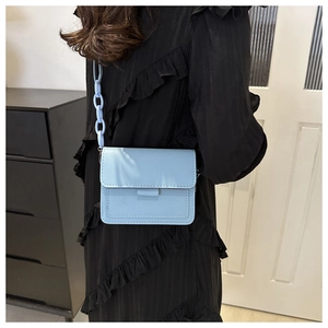 Borsa a tracolla azzurra con catena spessa mostrata indossata a spalla da una modella