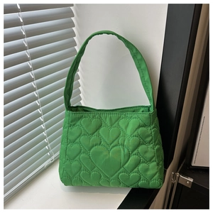 Détail du sac à main vert matelassé avec broderie coeur et texture en nylon doux