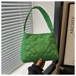 Détail d'un sac à main en nylon vert avec matelassage en cœur et poignée unique