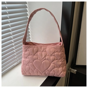 Vue détaillée du sac à main en nylon rose matelassé avec texture cœur et poignée souple