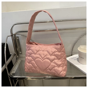 Détail du sac à main rose matelassé en forme de cœur avec une finition satinée élégante