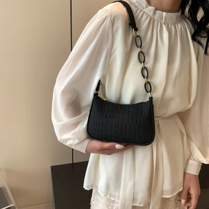 Chic black crocodile embossed shoulder bag with unique chain strap on model